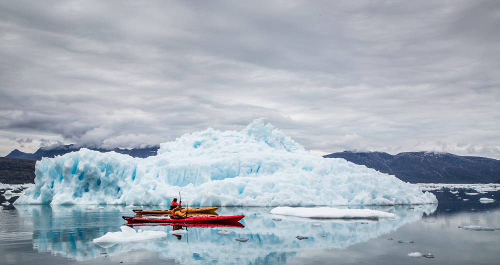 kayaking between icebergs at camp kiattua in greenland