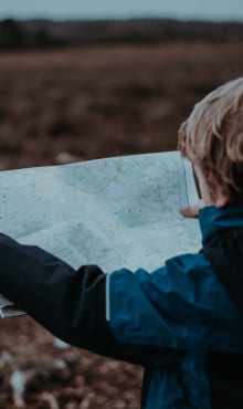 Boy looking at map on a mountain