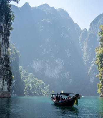 A boat travels through rocky outcrops in Thailand