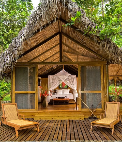 pacuare-lodge-room-suite-bed-four-poster-king-size-design-living-area-villa-exterior-terrace-deck-setting in costa rica