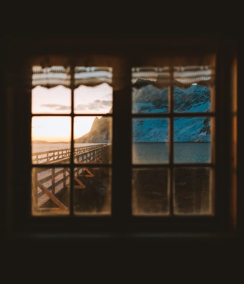 window overlooking the mountains in reine in norway