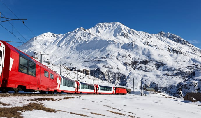 Glacier Express train against snow capped mountains