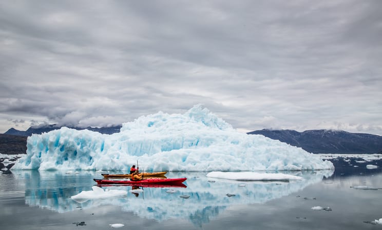 kayaking between icebergs at camp kiattua in greenland