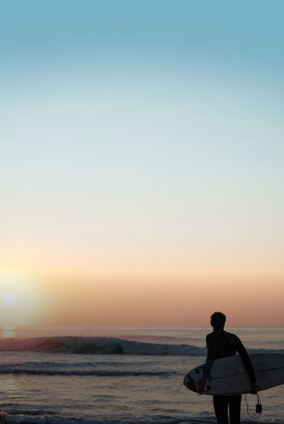 Surfer on a beach with sunset